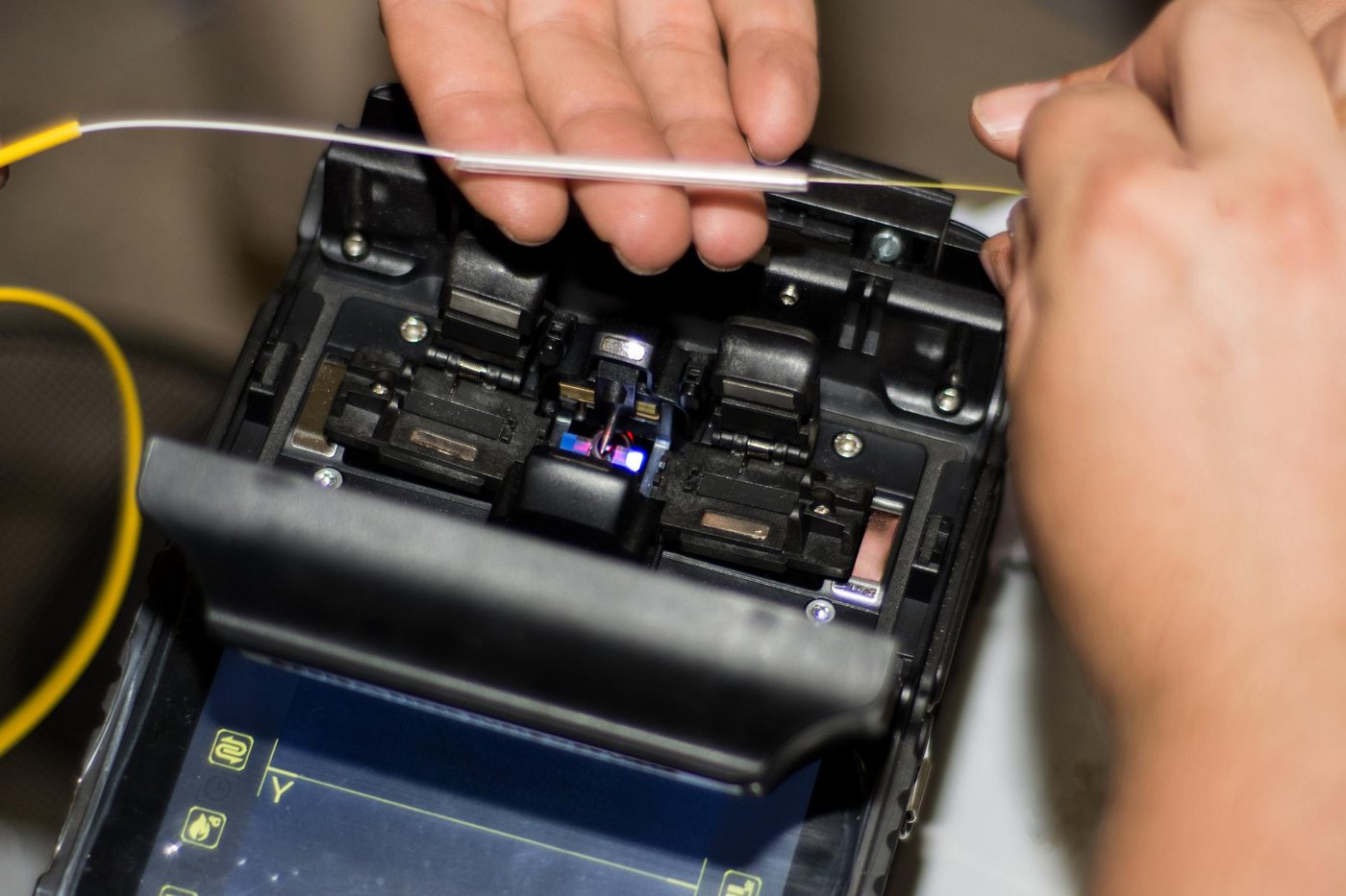 Técnico conectando fibra óptica em caixa de distribuição de rede